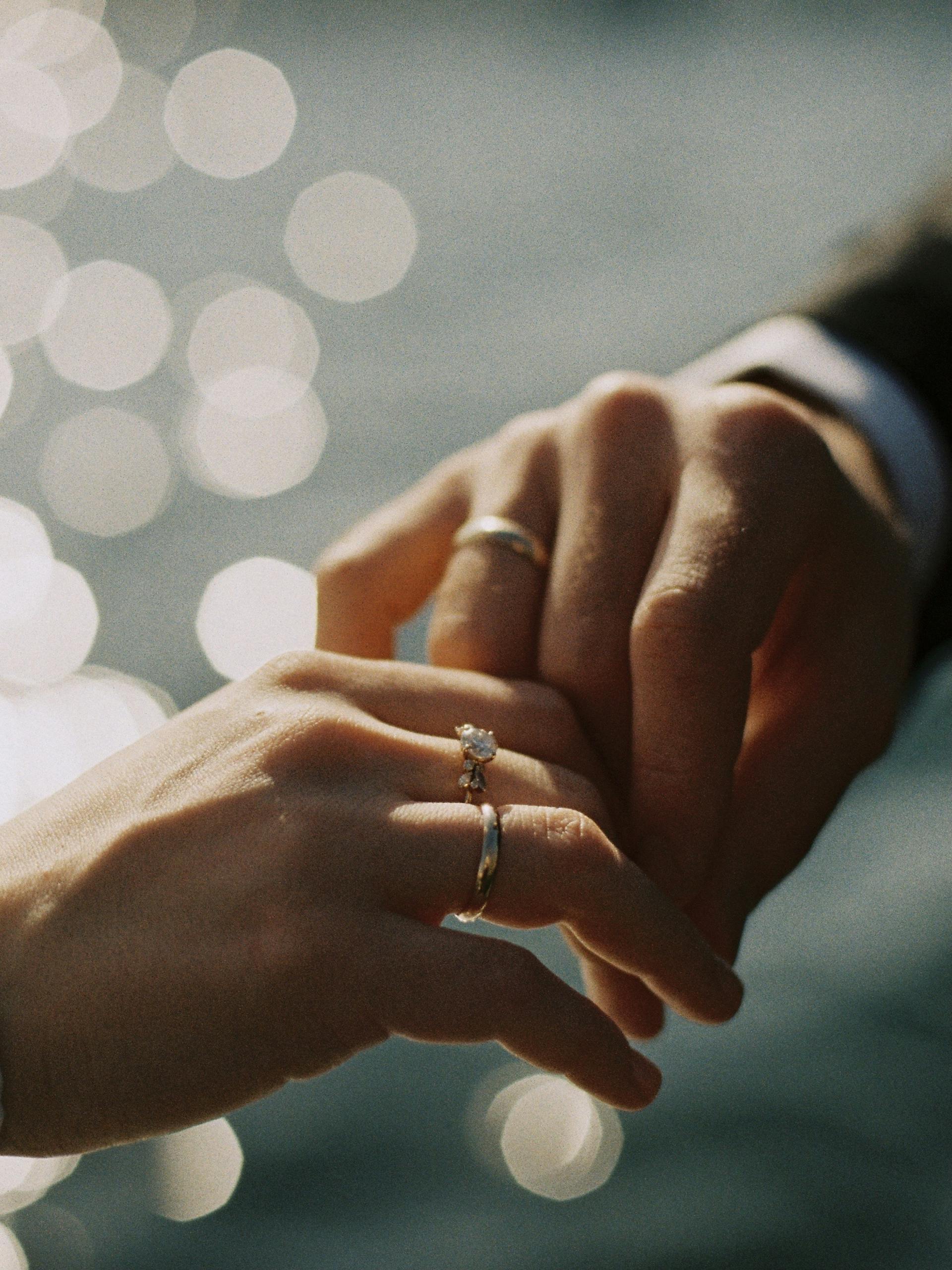 Intimate close-up of couple exchanging wedding rings, symbolizing love and commitment.